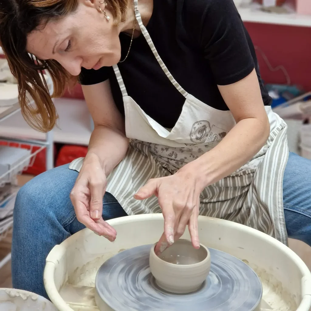 student centering and forming clay pottery wheel
